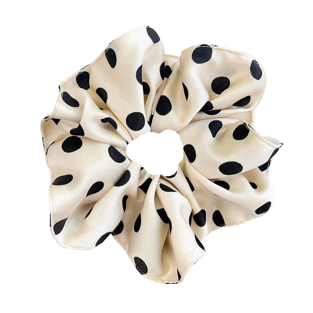 Cream-colored scrunchie with black polka dots held by a hand against a light background