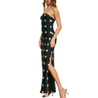 Black strapless dress with white polka dots on a white background