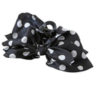 A black hair claw clip decorated with a large, layered ruffle bow made of black fabric with white polka dots, shown on a plain white background.