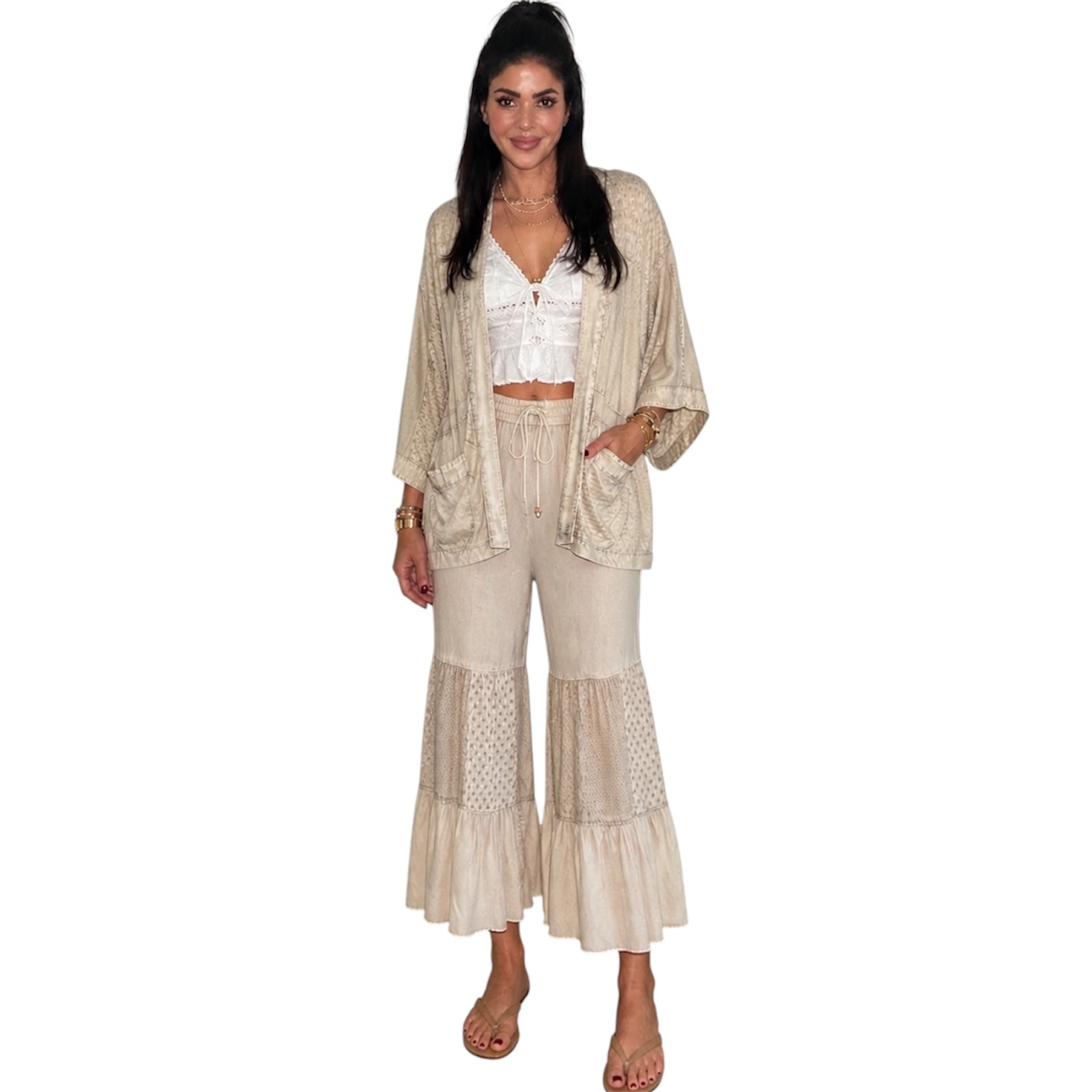 Woman wearing a beige outfit with a matching jacket and pants on a white background