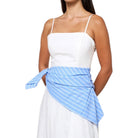 Woman wearing a white top and blue striped apron on a white background