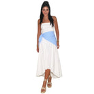 Woman wearing a white dress with a blue striped cover-up on a white background