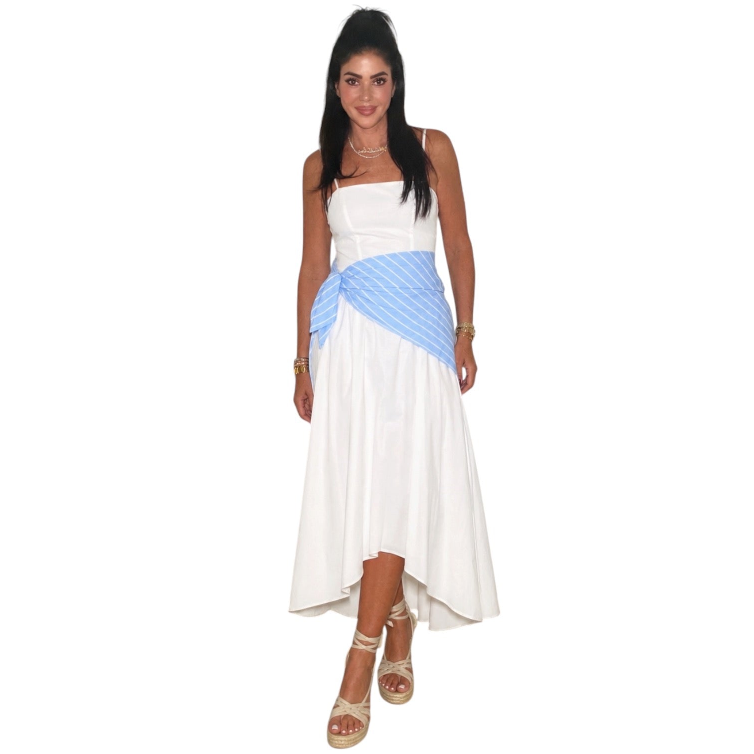 Woman wearing a white dress with a blue striped cover-up on a white background