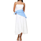Woman wearing a white dress with a blue striped cover-up on a white background