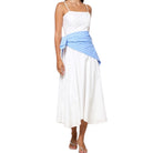 Woman wearing a white dress with a blue wrap on a white background