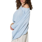 Woman wearing a light blue wrap over one shoulder on a white background