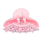 A light pink hair claw clip adorned with iridescent pearl-like beads along the lower curve, shown against a plain white background.