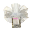 A bottle of nail polish with a large white tulle bow around the neck, shown on a plain white background. The nail polish inside the clear glass bottle appears shimmering silver.