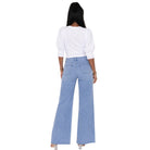 A woman shown from the back wearing a white puff-sleeve top and light blue wide-leg jeans against a plain white background.