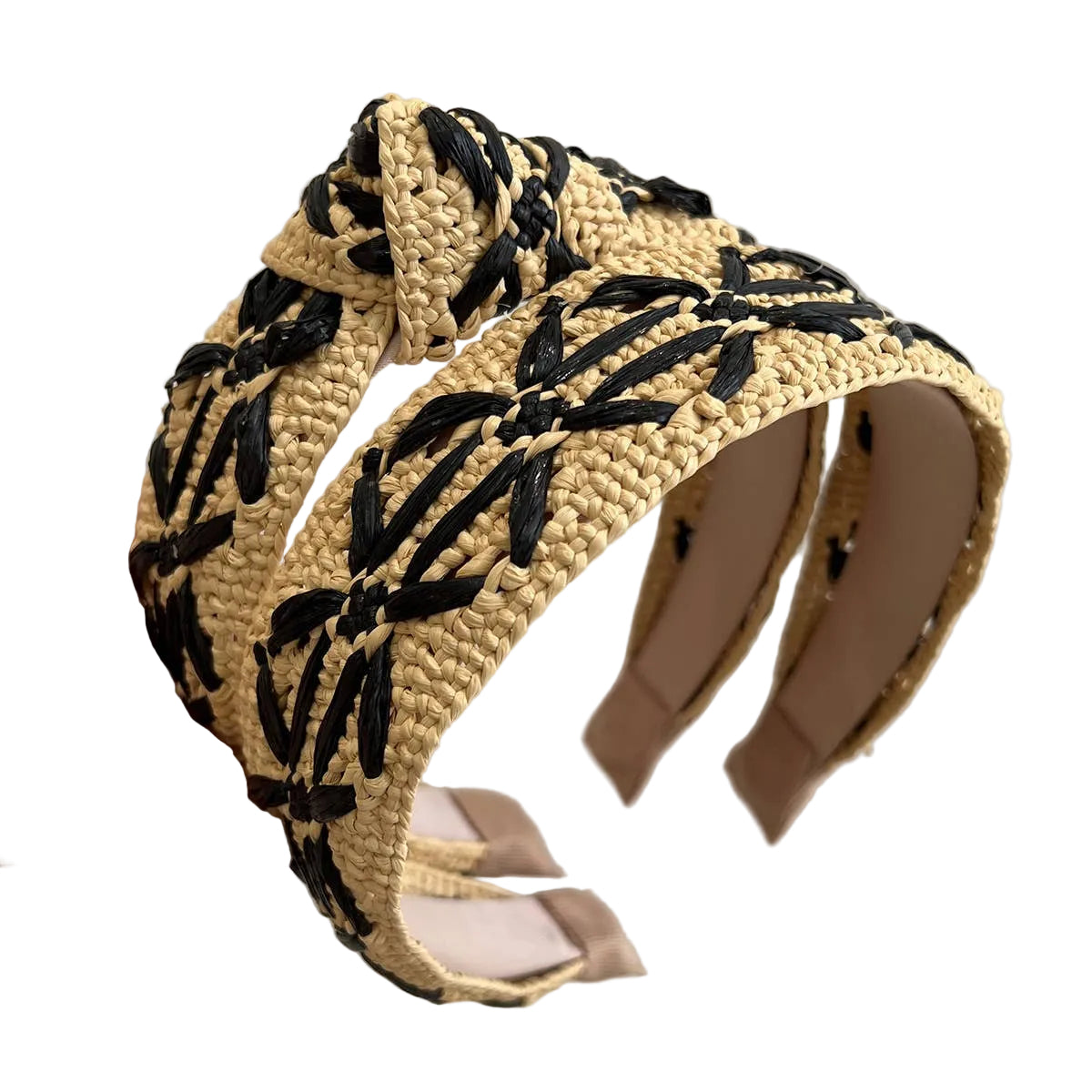 Woven headband with black leaf patterns held by a hand against a neutral background