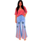 Woman wearing a red top and blue pants with star designs on a white background