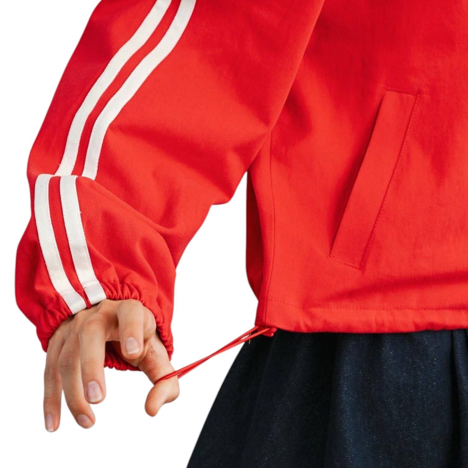 Red jacket with white stripes on sleeves and a hand adjusting a drawstring.