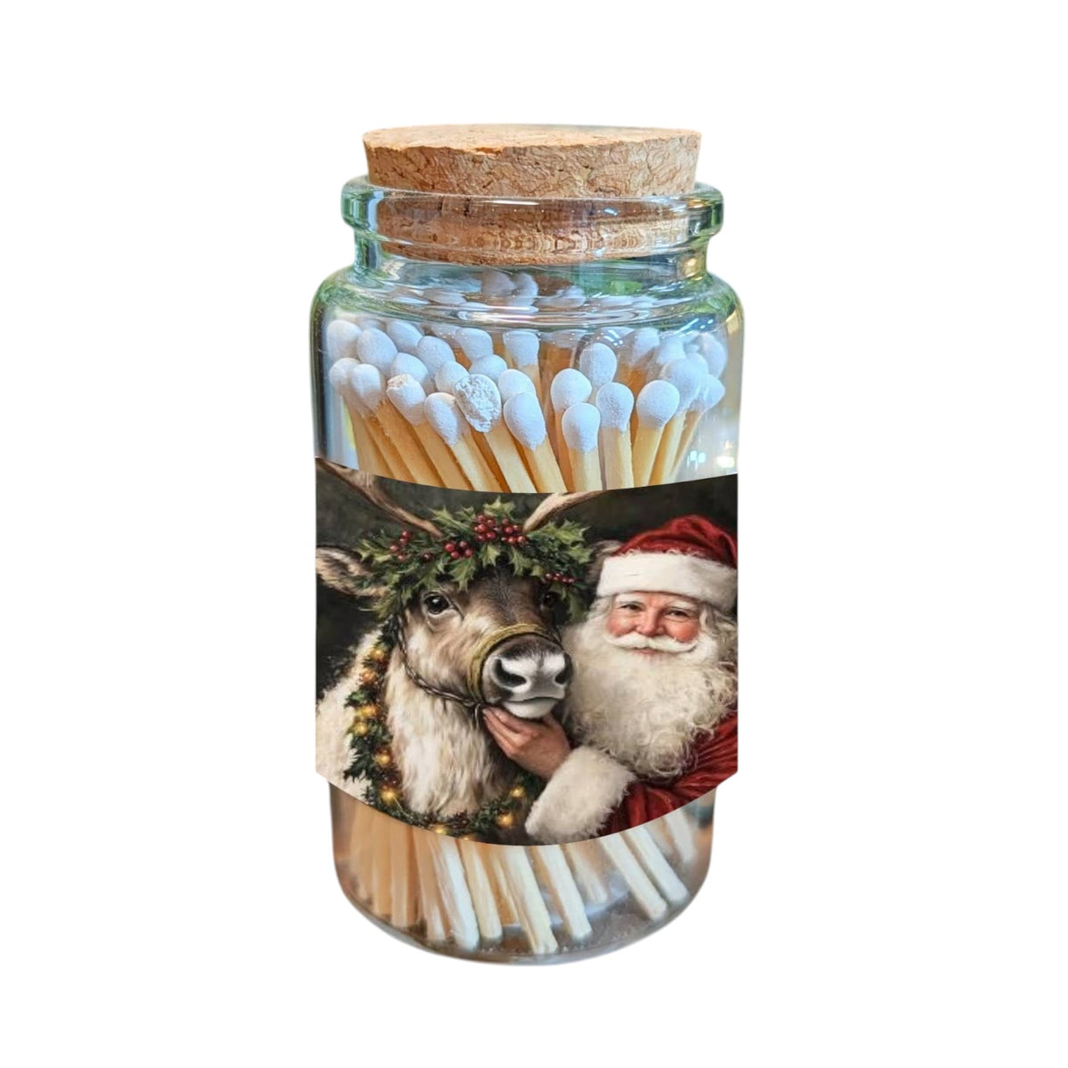 A clear glass jar filled with wooden matches, sealed with a cork stopper and wrapped in a festive Christmas label showing Santa Claus and a reindeer, on a plain white background.