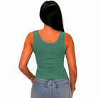 A woman viewed from the back wearing a fitted sage green tank top and light blue jeans against a plain white background.