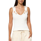 Woman wearing a white sleeveless top with cut-out details on a white background