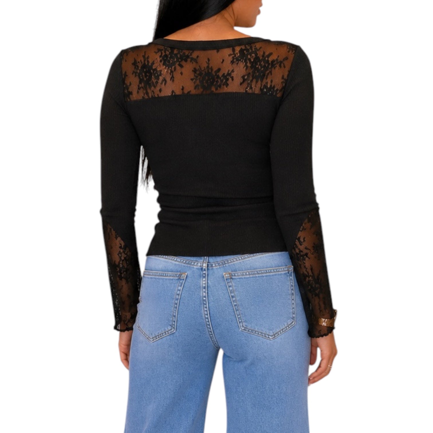 A woman shown from the back wearing a black long-sleeve top with sheer black lace panels across the shoulders and down the sleeves, paired with light blue jeans, against a plain white background.