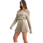 Woman wearing a beige off-shoulder sweater dress on a white background