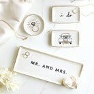 Set of decorative trinket dishes with 'i do', 'Mr. and Mrs.', and car illustrations on a white surface.
