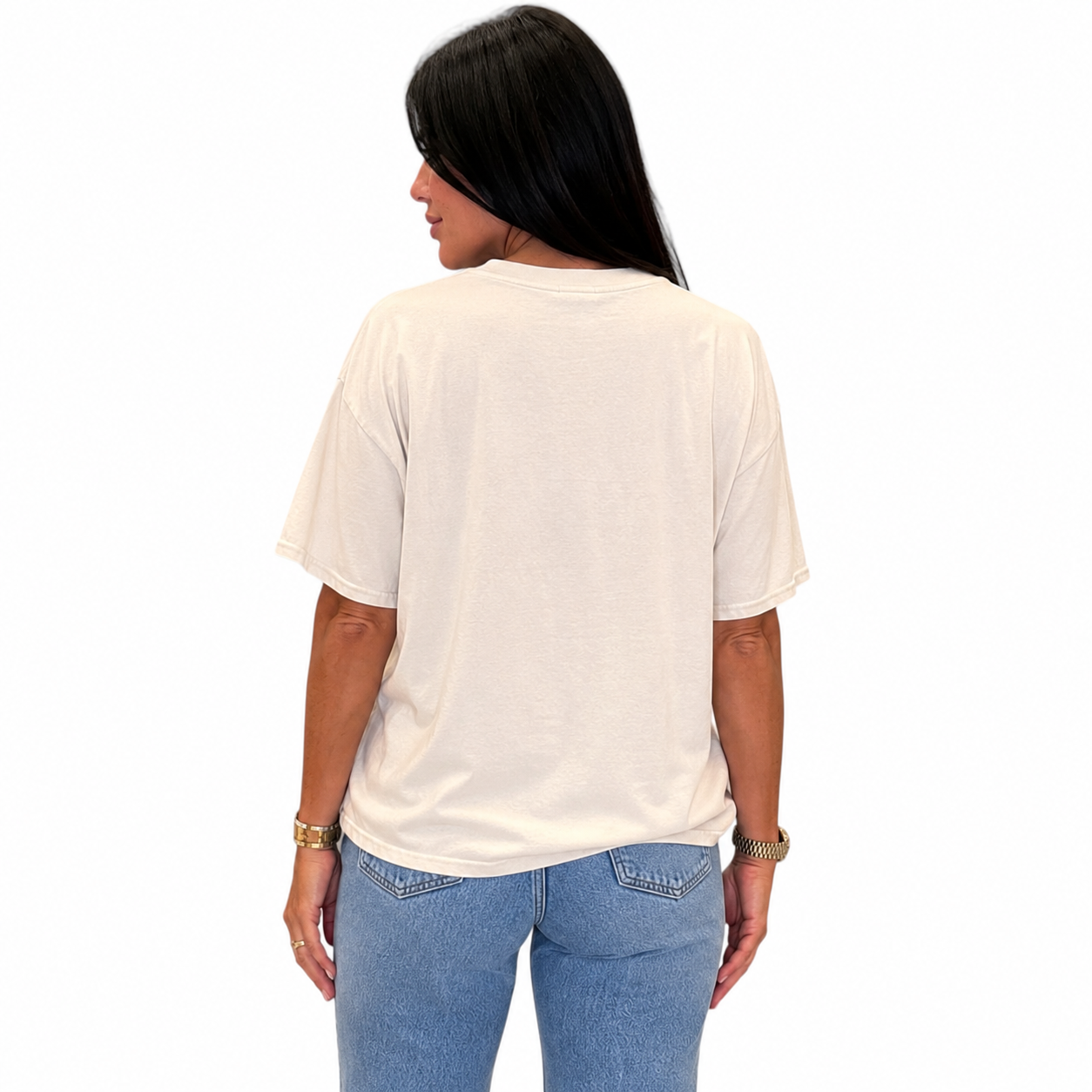 A woman viewed from the back wearing an oversized off-white t-shirt and light blue jeans, set against a plain white background.