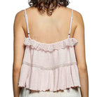 Pink lace top worn by a person on a white background
