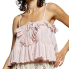 Light pink lace top worn by a person on a white background