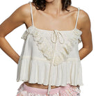 cream lace top with ruffled details on a white background