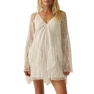 Woman wearing a white lace romper on a white background