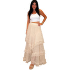 Woman wearing a white top and beige layered skirt on a white background