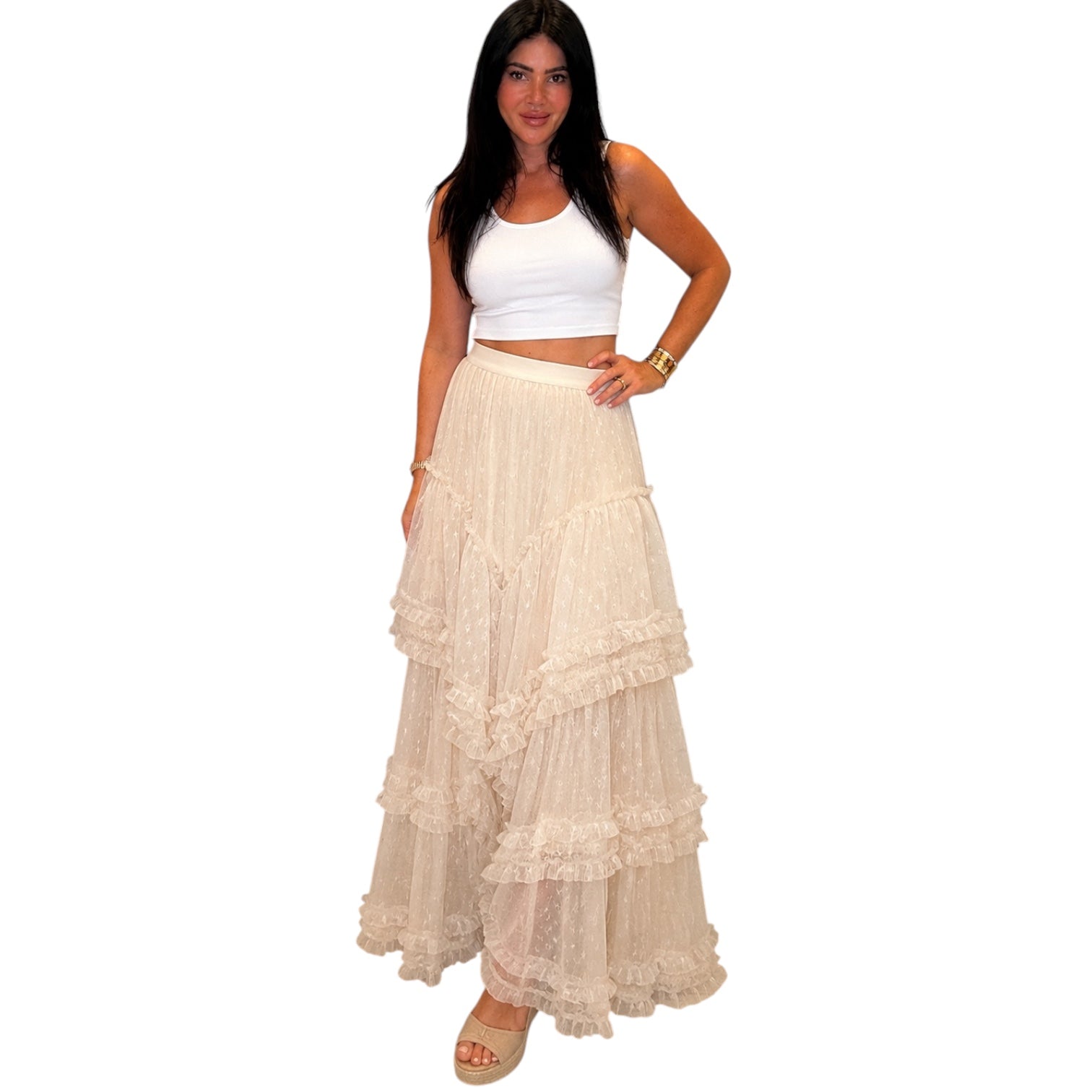Woman wearing a white top and beige layered skirt on a white background