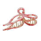 Pink and gold hair clip on a light gray background