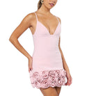 Woman wearing a pink dress with floral details on a white background