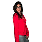 Woman wearing a red blouse with a knot detail on a white background