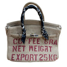 Handbag designed like a coffee bag with text and black handle scarf on a white background