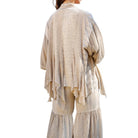 Beige layered outfit with a patterned top and wide-leg pants on a white background