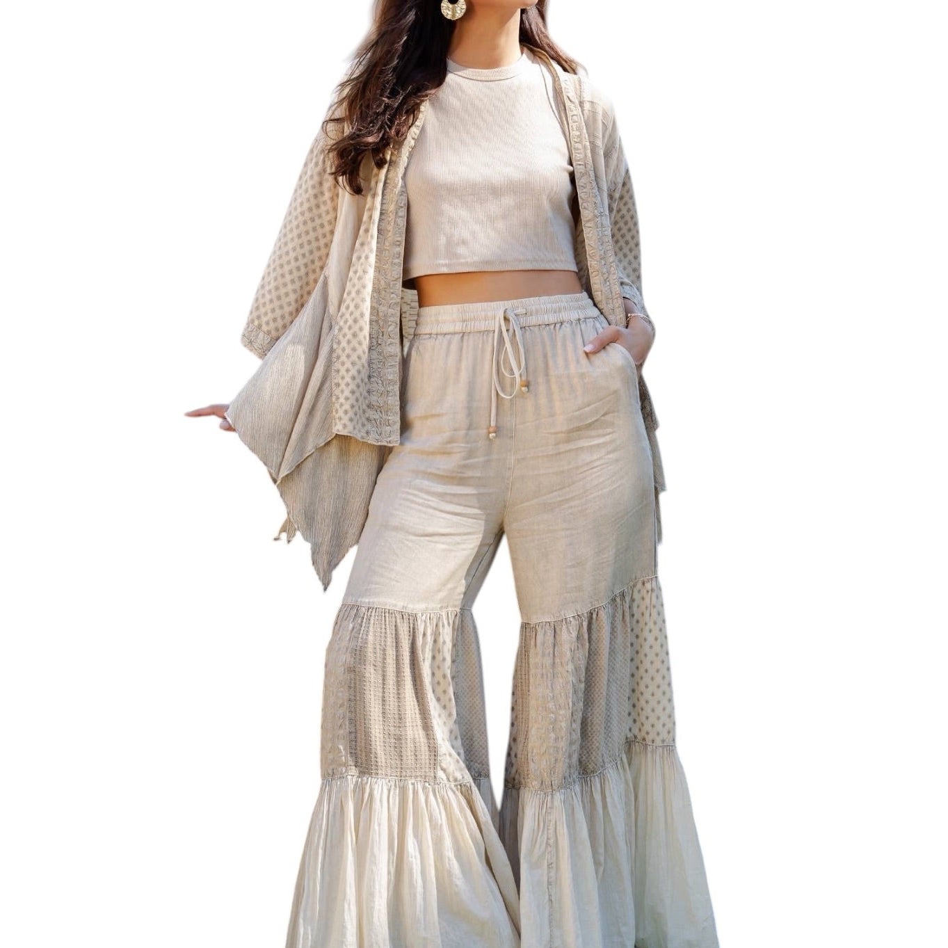 Woman wearing a beige outfit with a matching cardigan on a white background