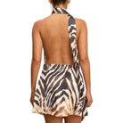 Woman wearing a zebra print halter dress on a white background