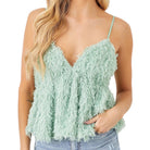 Light green feathered top worn by a person on a white background