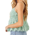 Light green feathered top worn by a person on a white background