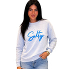 Woman wearing a light blue sweatshirt with 'Salty' in blue text on a white background