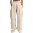 Beige wide-leg pants worn by a person on a white background