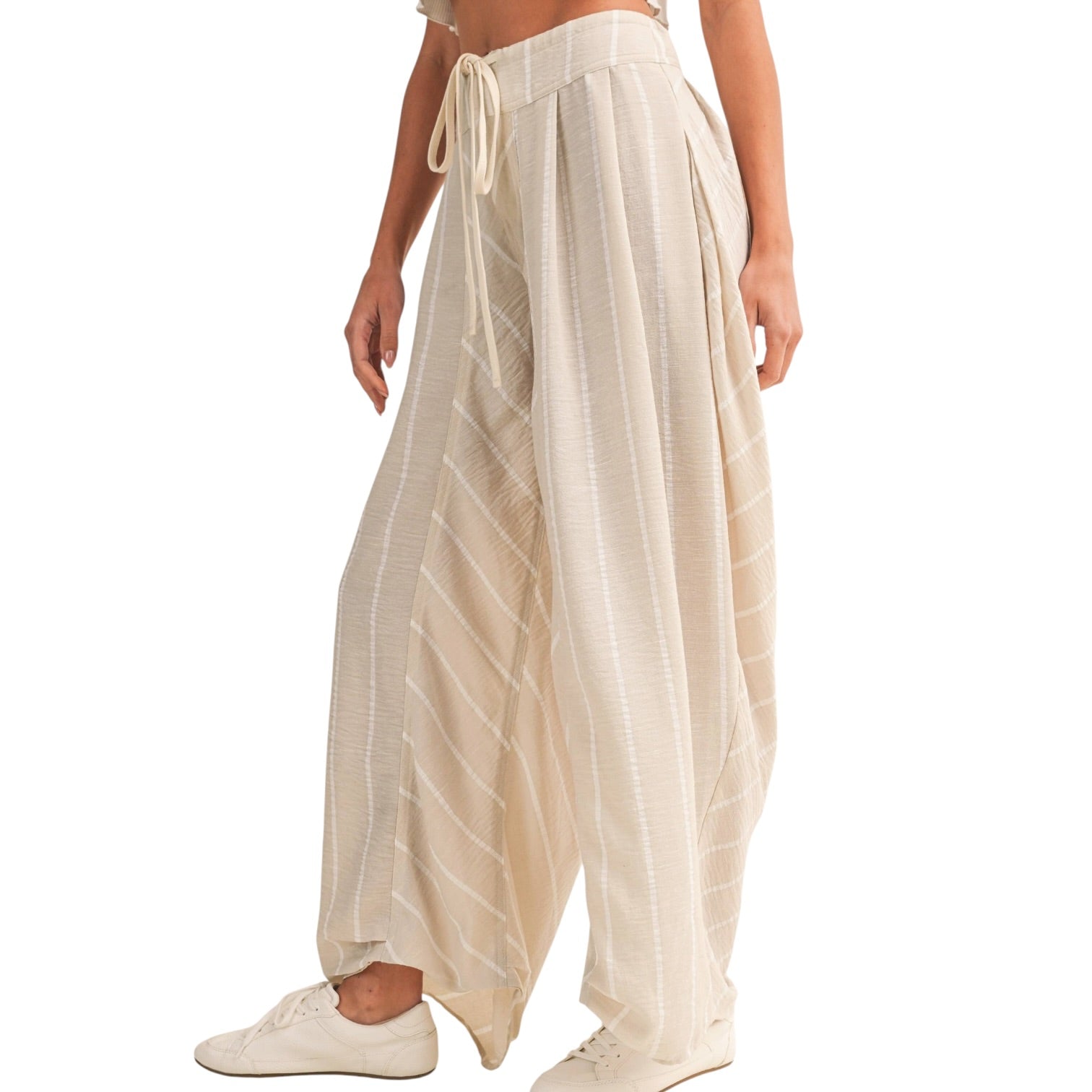 Beige wide-leg pants worn by a person on a white background