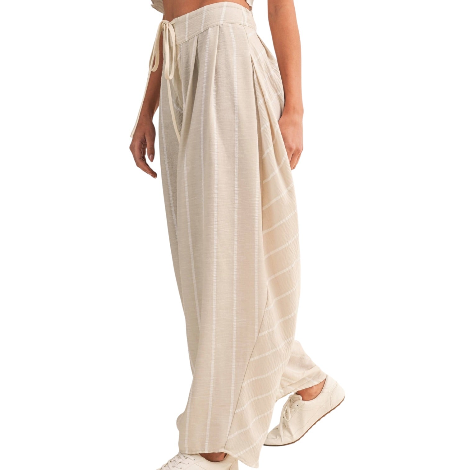 Beige wide-leg pants worn by a person on a white background