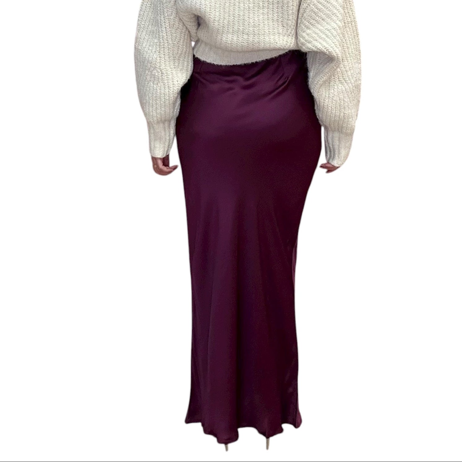 Person wearing a sweater and burgundy skirt on a white background