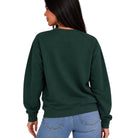A woman shown from the back wearing a dark forest green crewneck sweatshirt and light blue jeans against a plain white background.