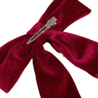 A deep burgundy velvet hair bow with a silver metal hair clip, shown against a plain white background.