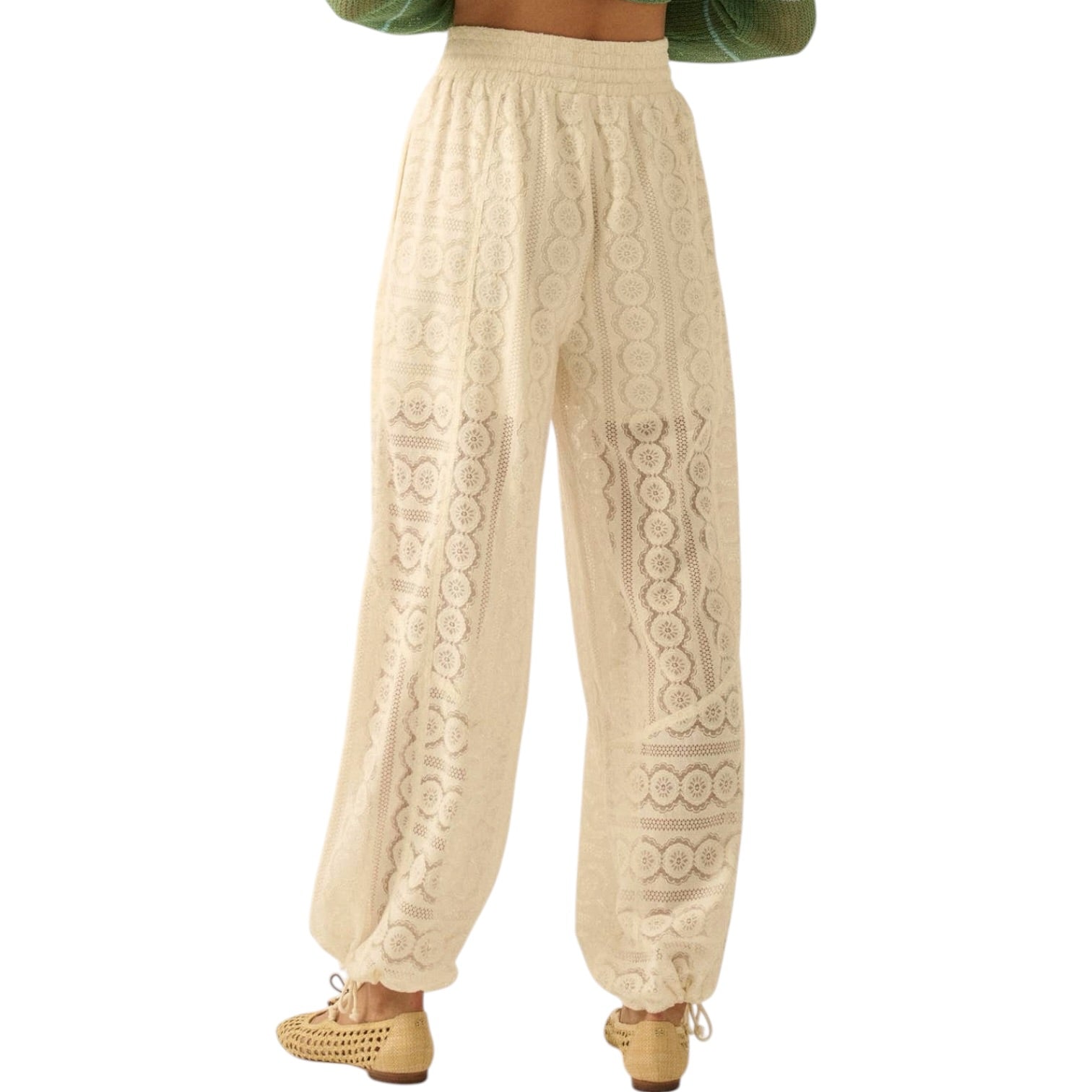 Beige lace pants worn by a person on a white background