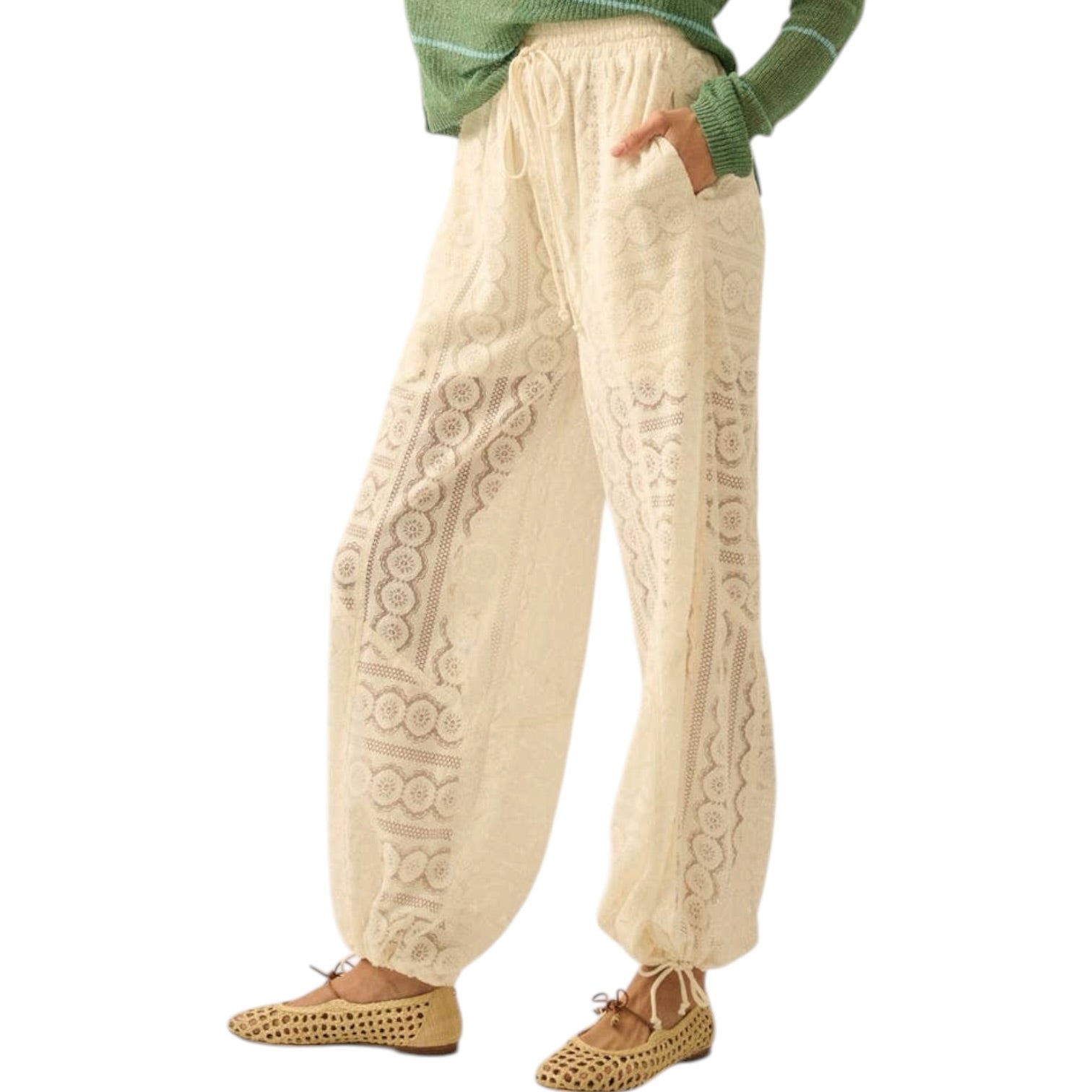 Beige cable knit pants worn by a person on a white background