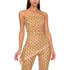 Woman wearing a beige strapless jumpsuit with a textured pattern on a white background