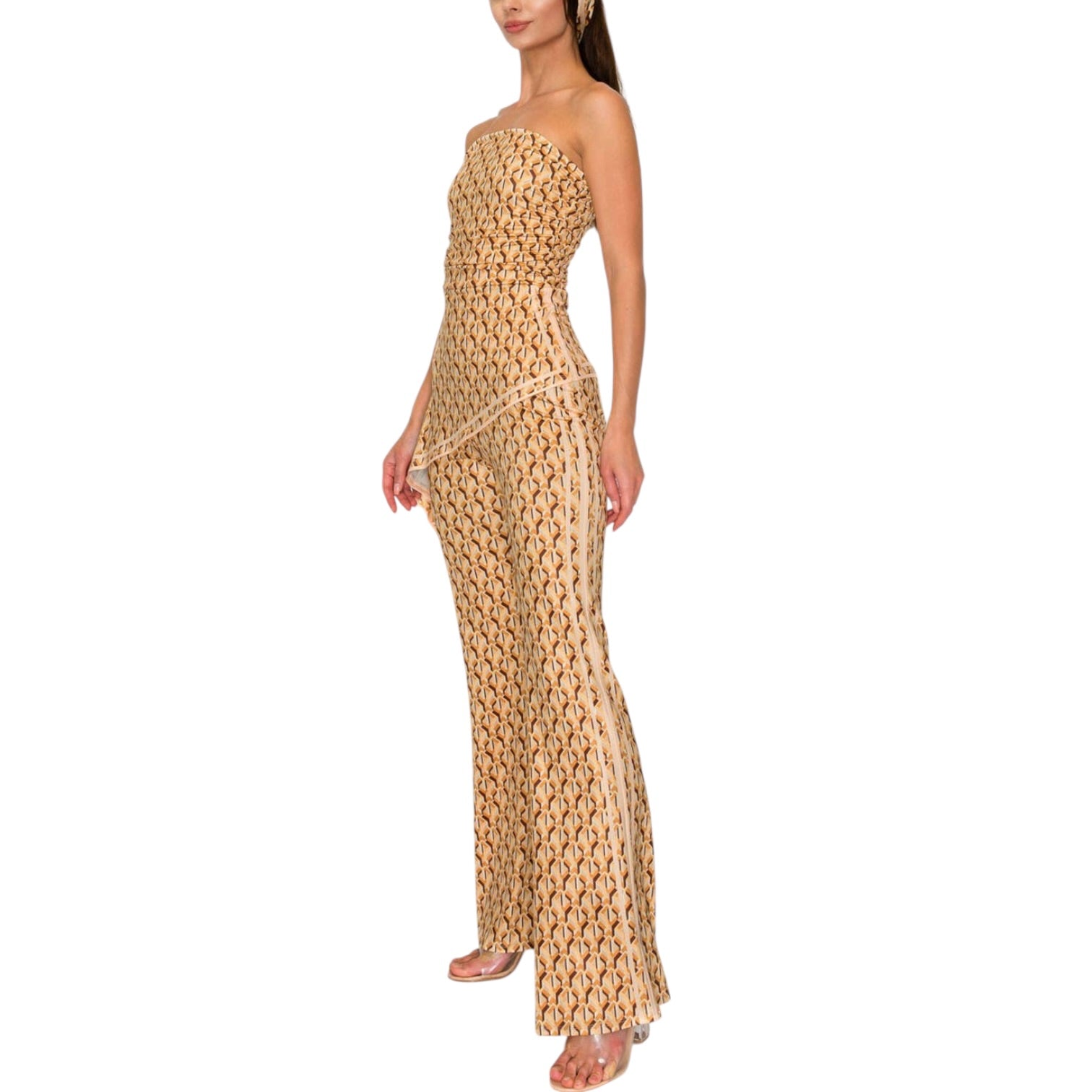 Woman wearing a strapless, patterned gold dress on a white background