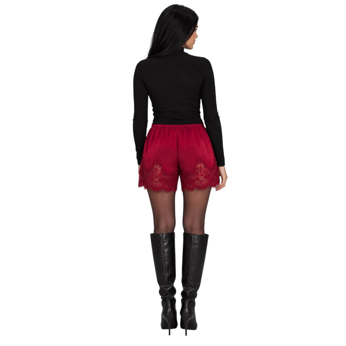 A woman shown from the back wearing a black long-sleeve top, red lace-trimmed shorts, sheer black tights, and black knee-high boots against a plain white background.